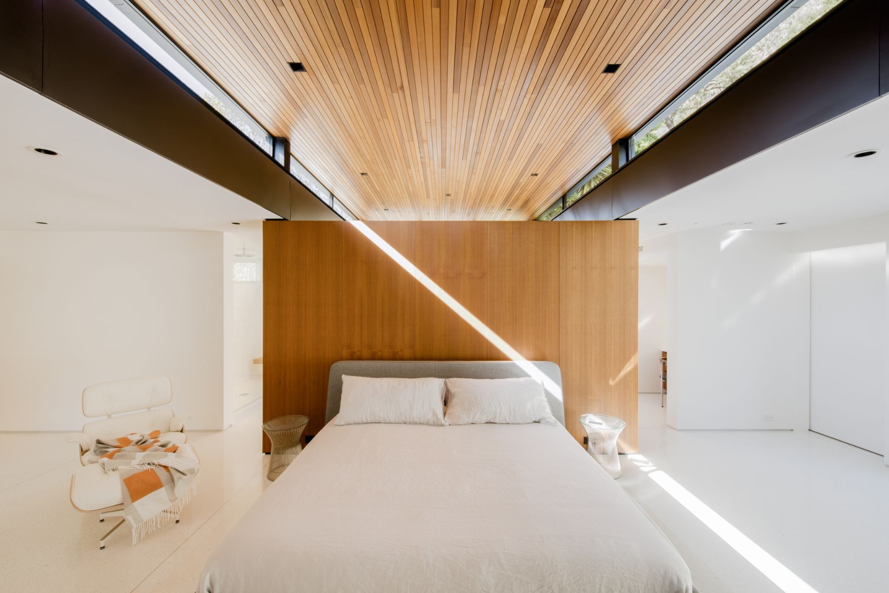 Light falling across the teak bedroom wall